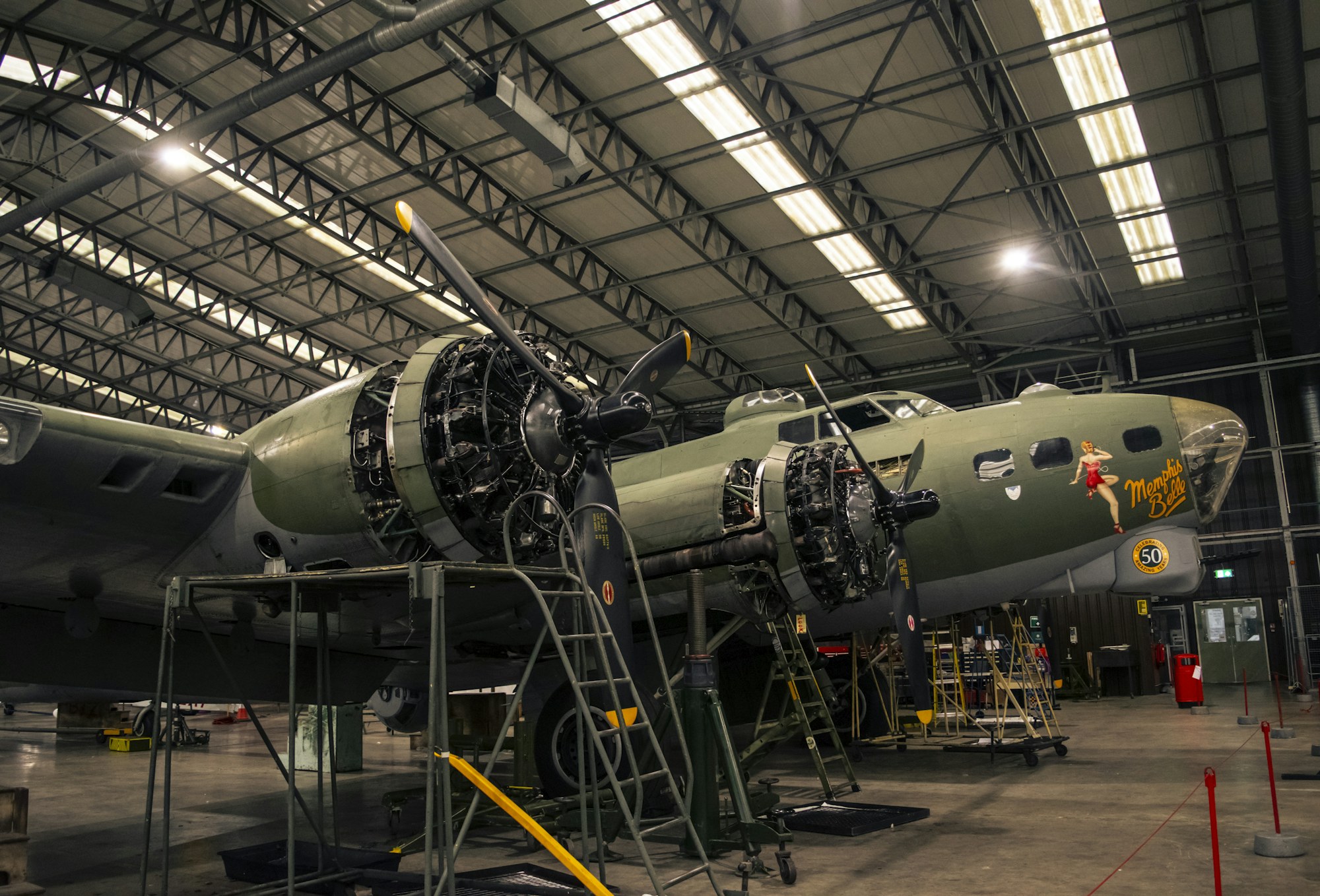 Aircraft undergoing maintenance inside an aviation hangar